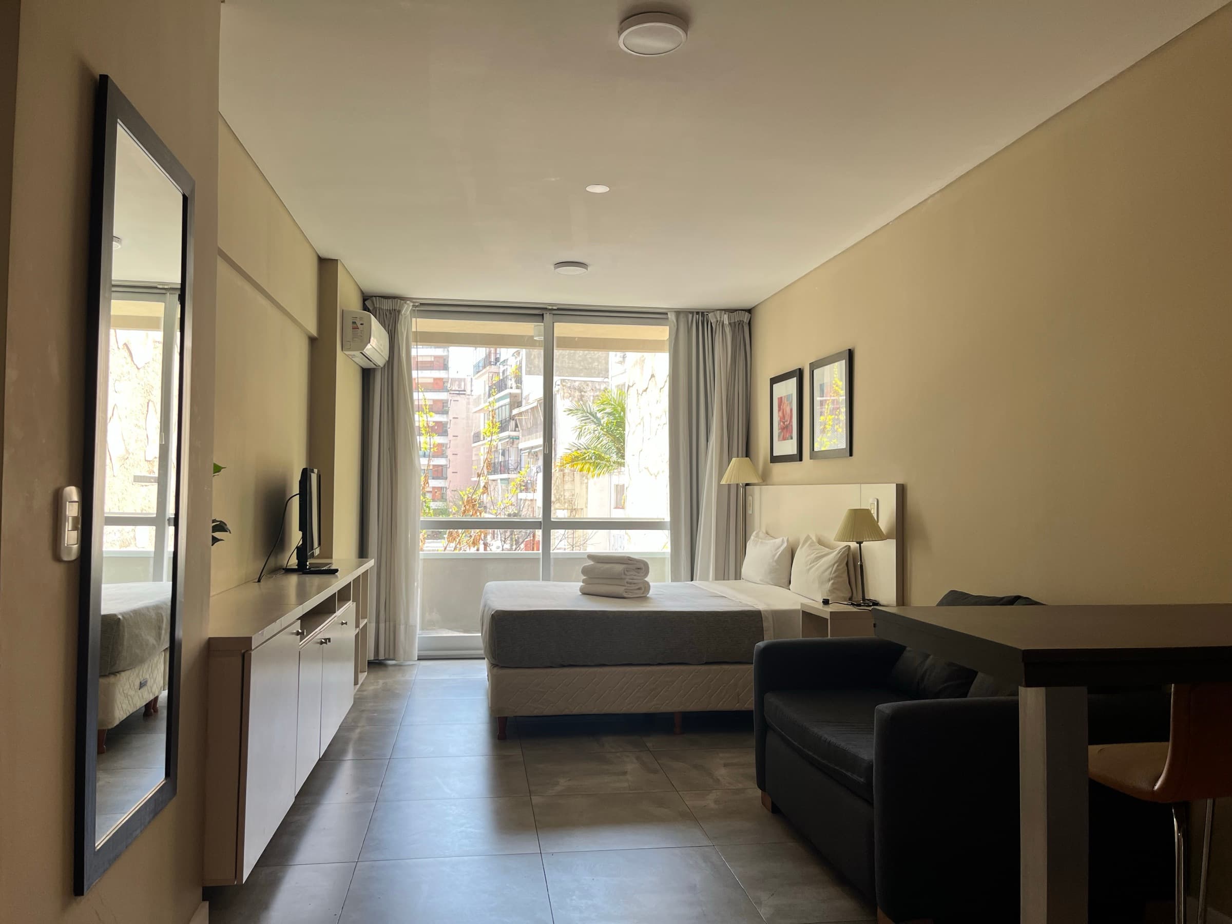 Ambiente completo con dormitorio, living y ventanal