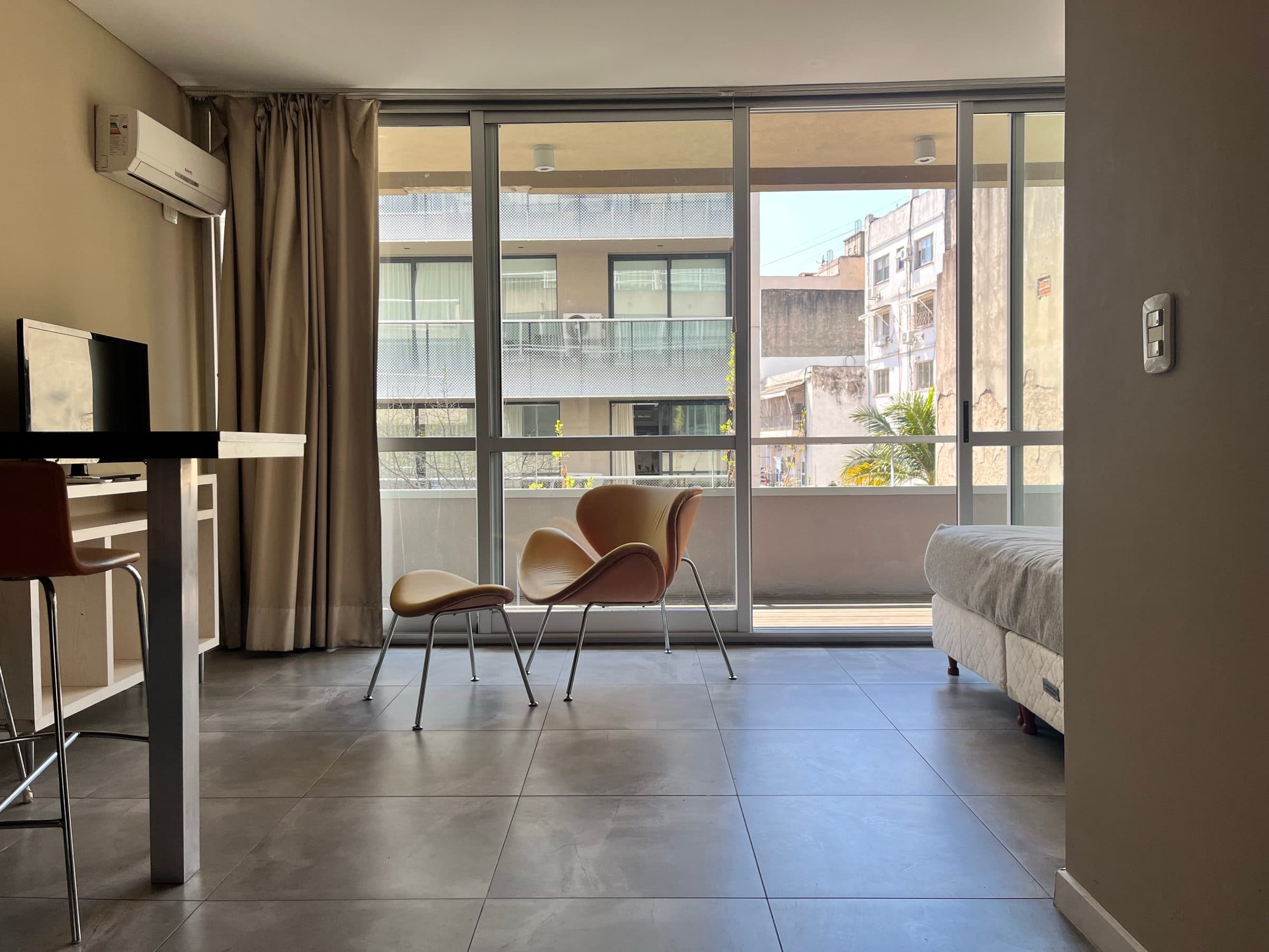 Living de Marais Recoleta con ventanal al balcón